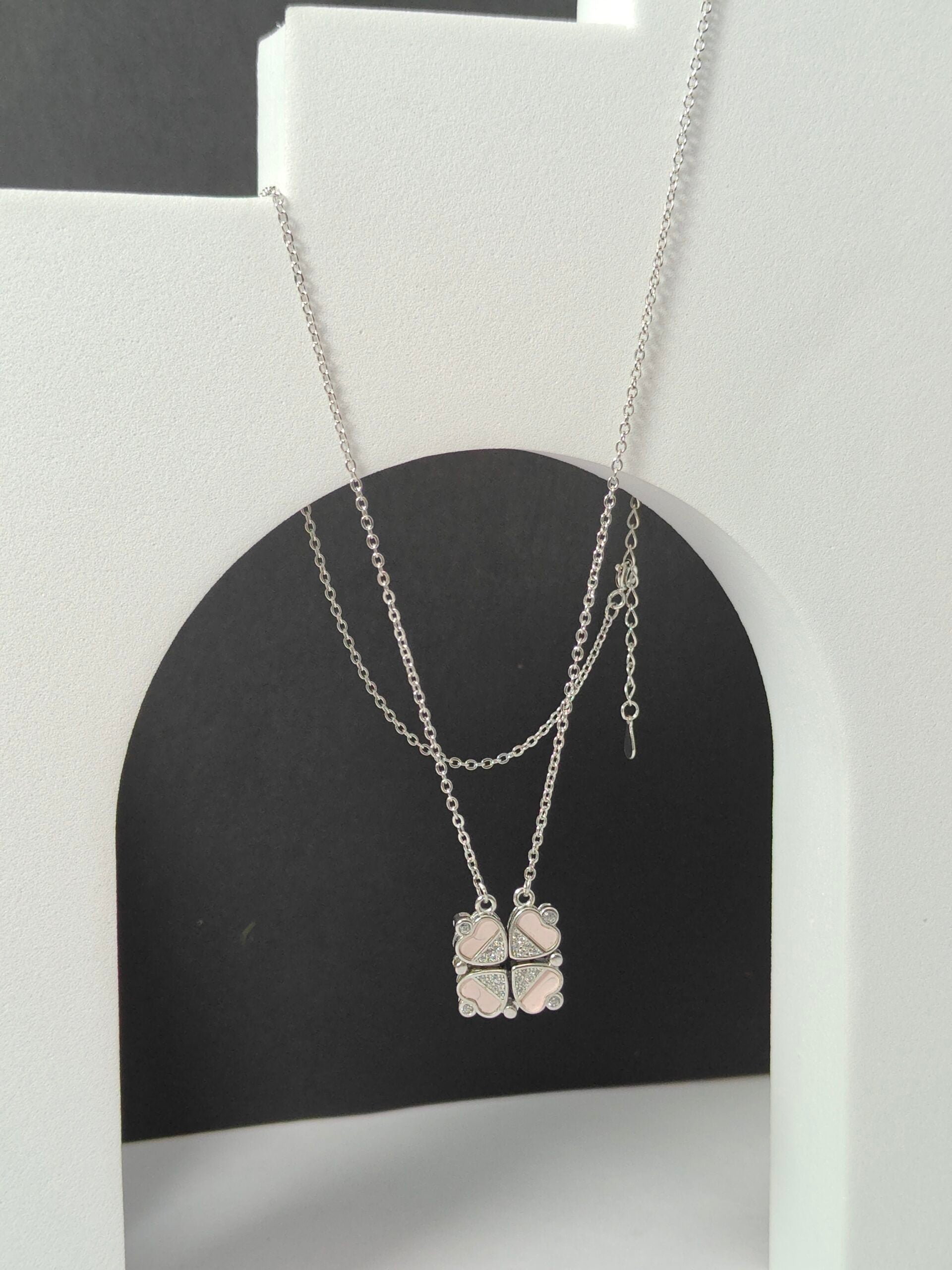 Silver necklace with a clover pendant on a white and black background